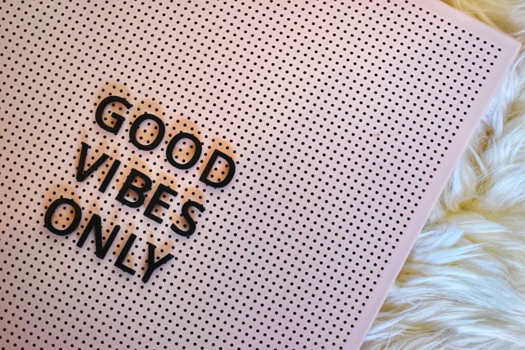 Good vibes only written on a pink board in letter tiles on a fluffy background