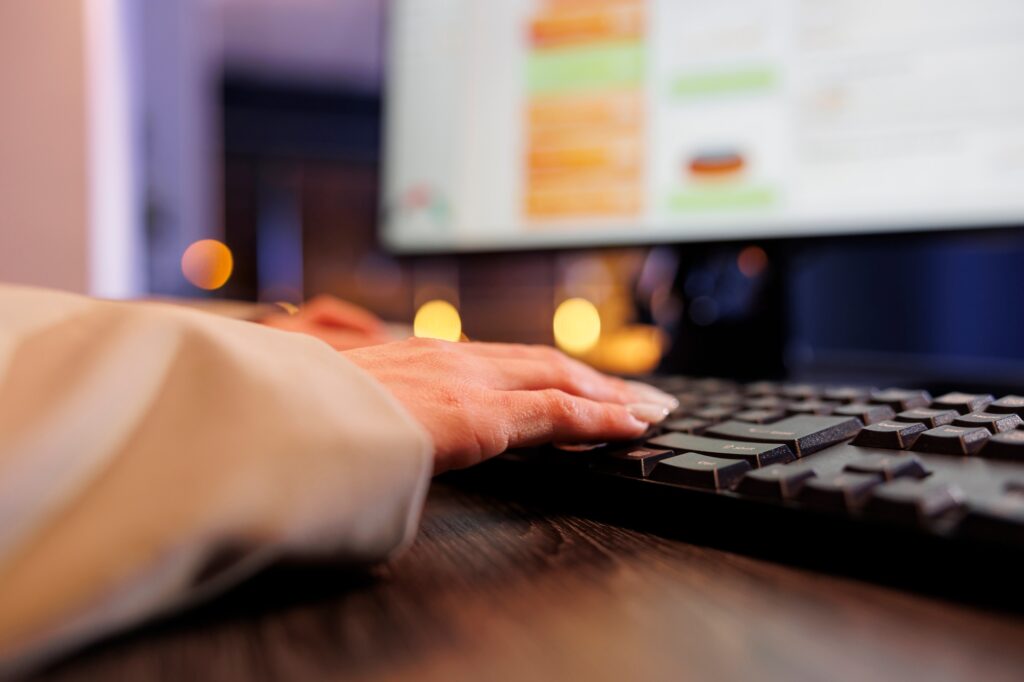 Corporate worker typing financial strategy on computer