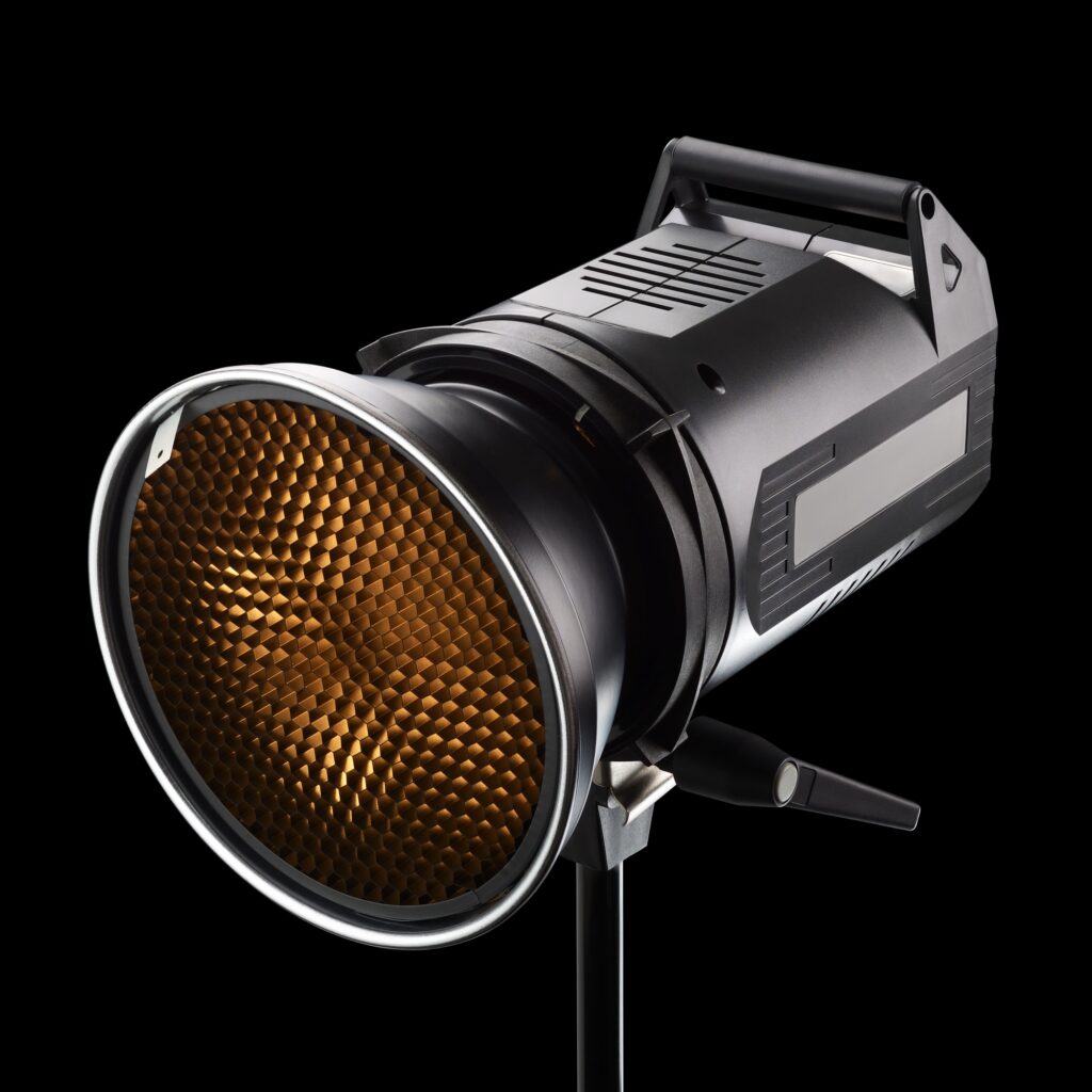 Photography studio flash with honeycomb on black background