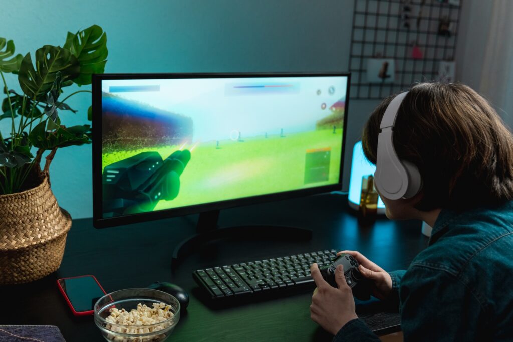 Young girl gamer playing video shooting game online - Technology trend concept